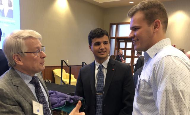 Two students speak with the president of the American Institute of Aeronautics and Astronautics and a student run conference
