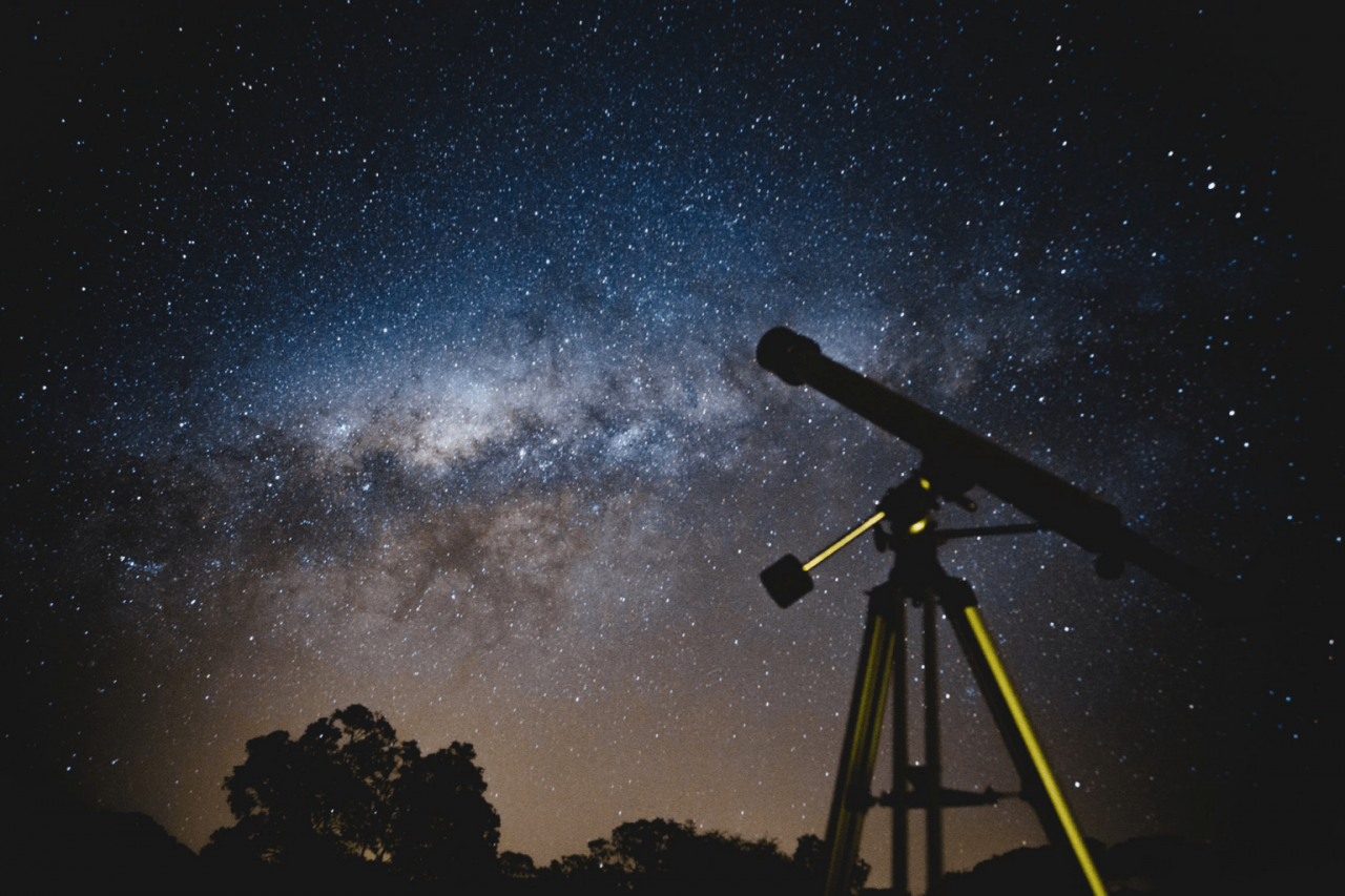 A telescope aimed up at the milky way in the sky