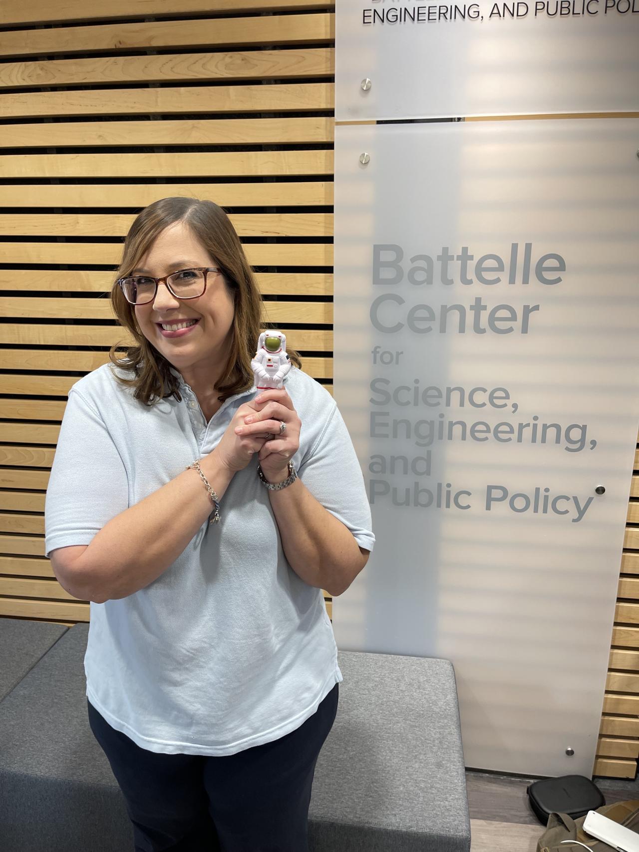 Dr. Azlin Labiosa holding a small astronaut in the Battelle Center