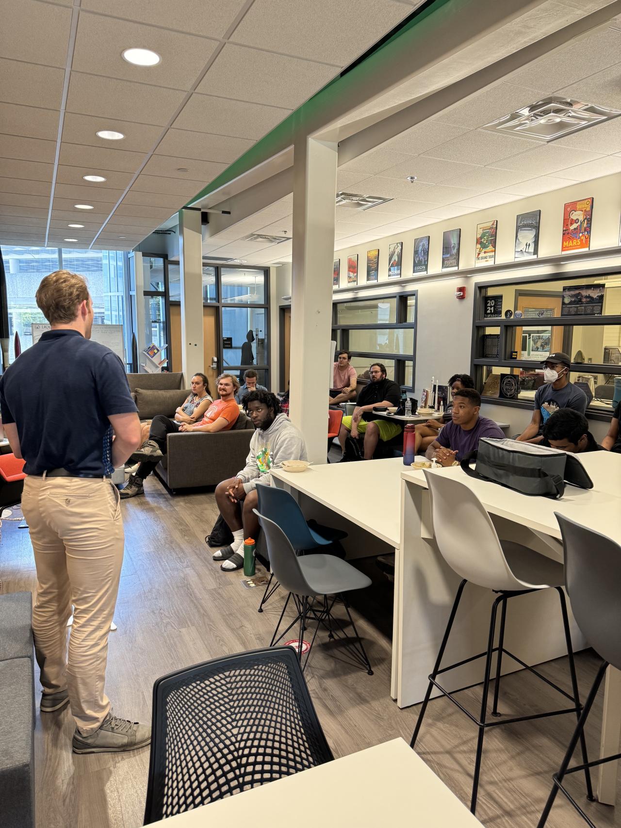 Full view of a room of students facing a speaker whose back is to the camera