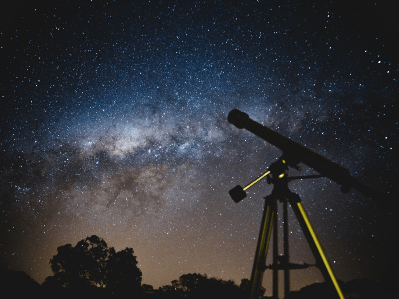 A telescope aimed up at the milky way in the sky