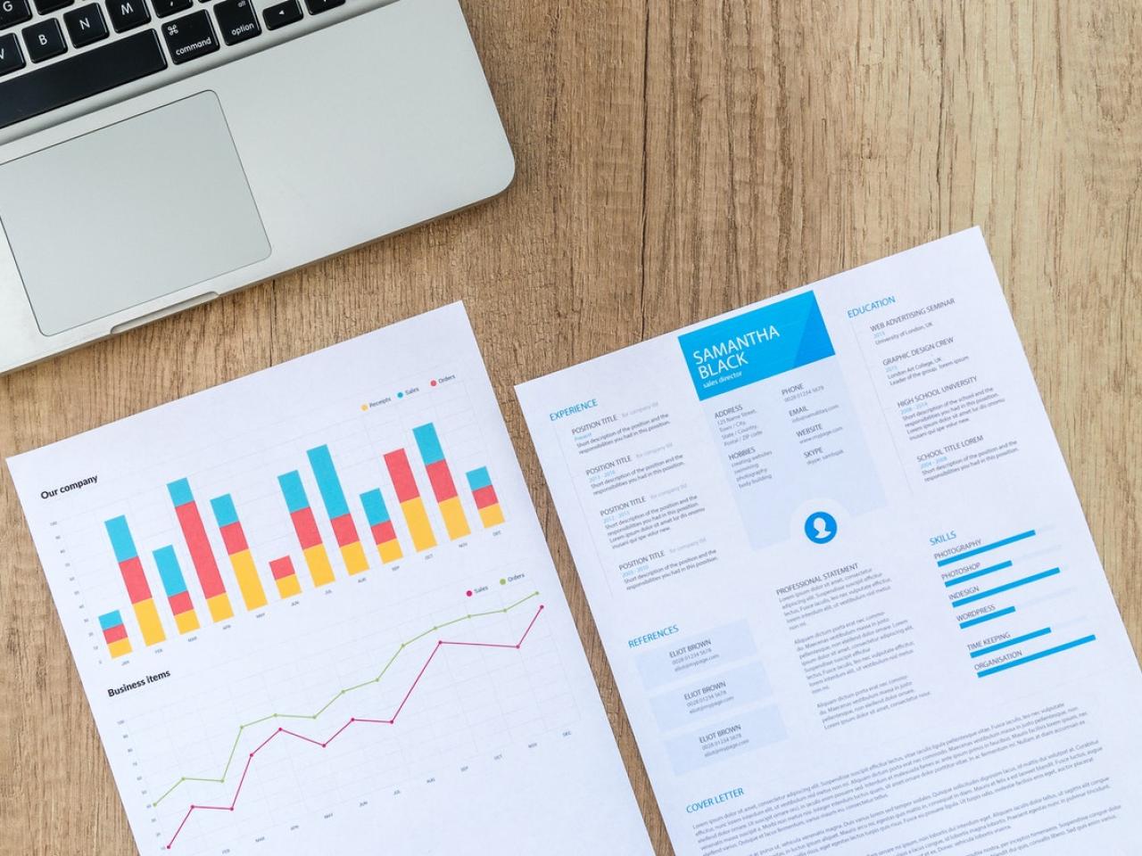 A picture of a two-page resume on a desk next to a laptop