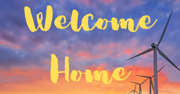 Welcome Home in Yellow with a sunset and windmills in the background