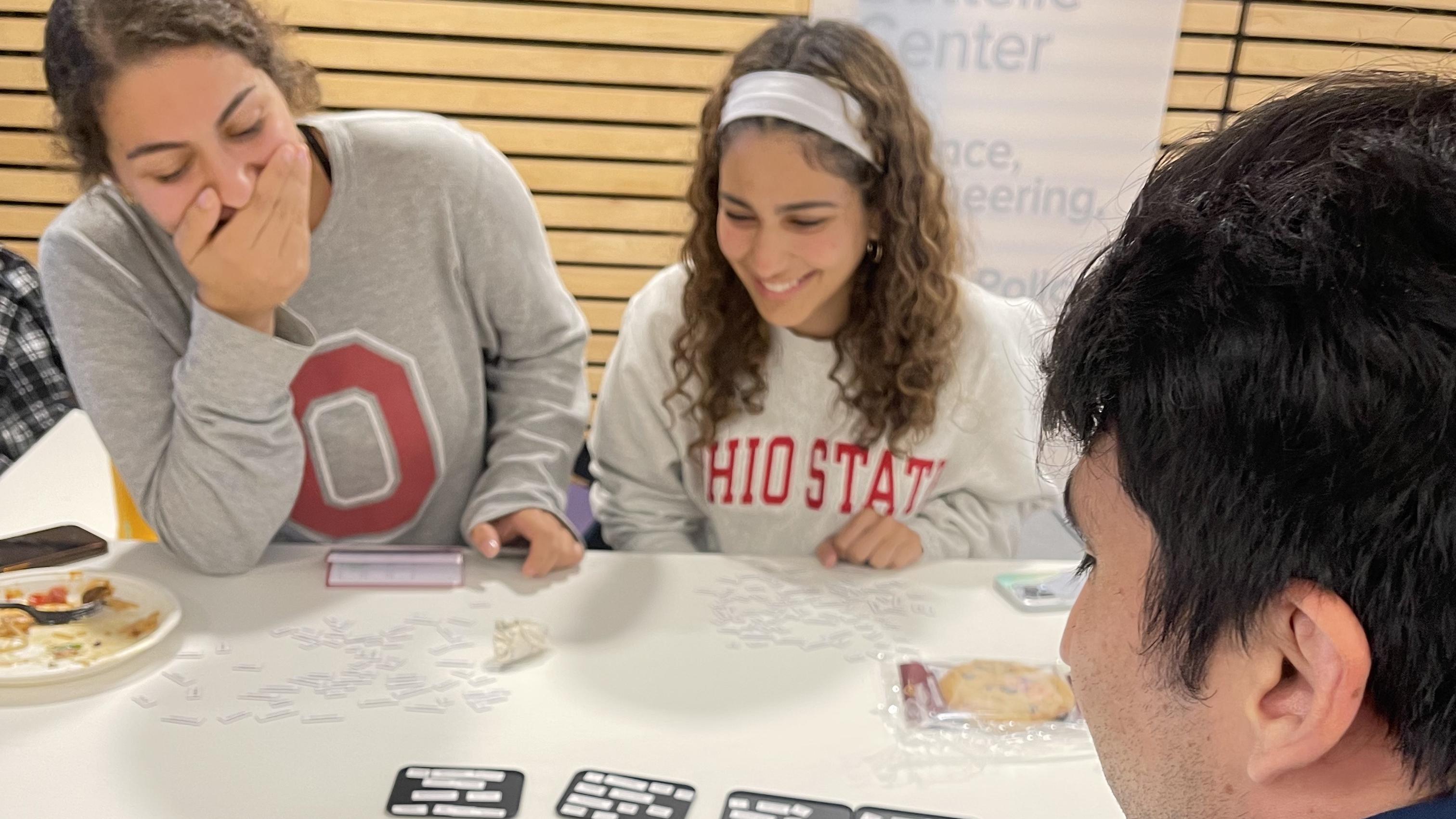 Students laughing around a table while playing Ransom Notes