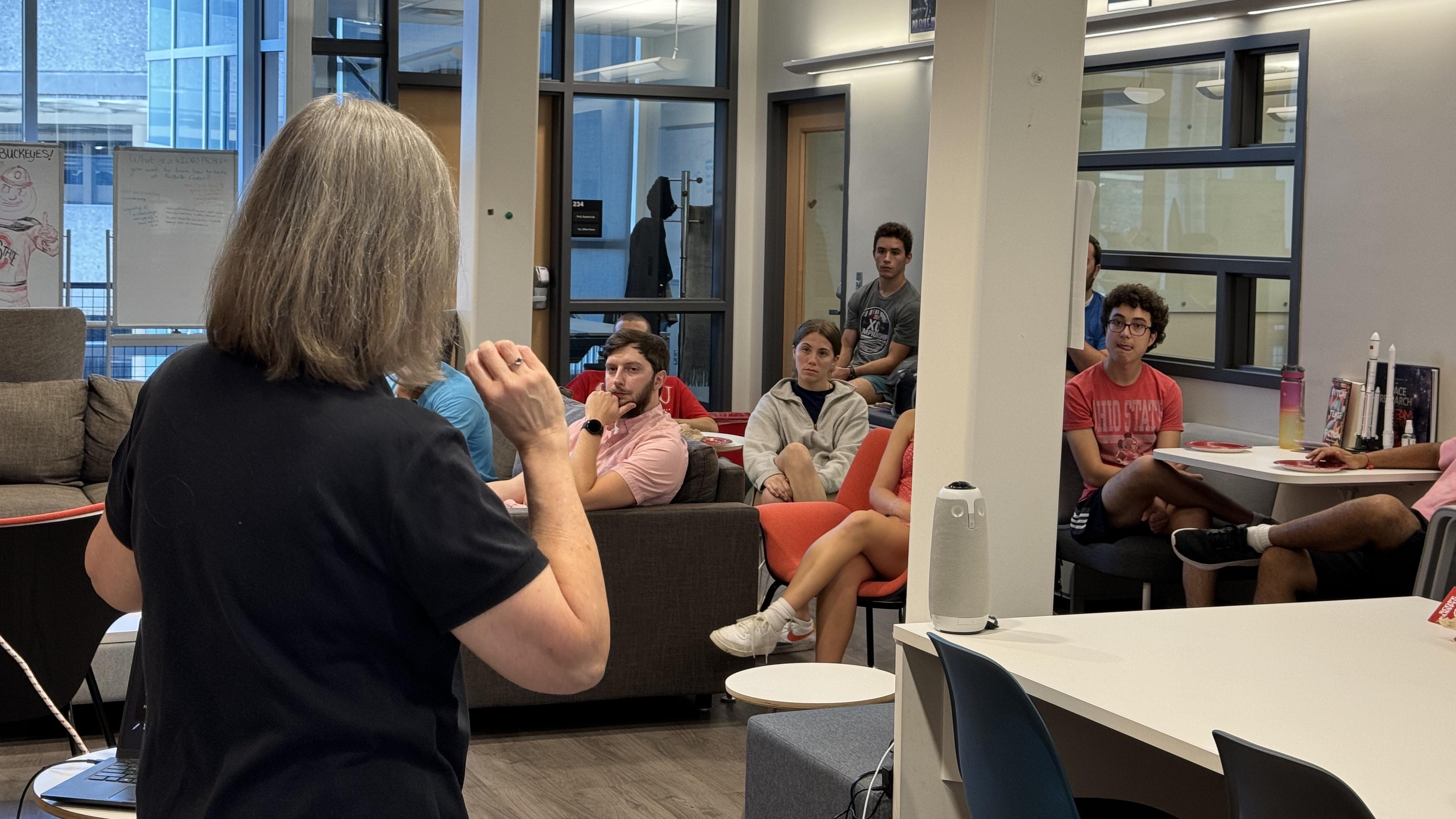 Alice Bowman with her back to the camera speaking to a room full of students.